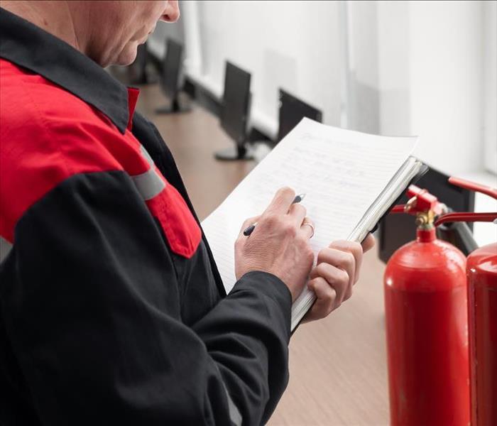 person inspecting fire extinguishers